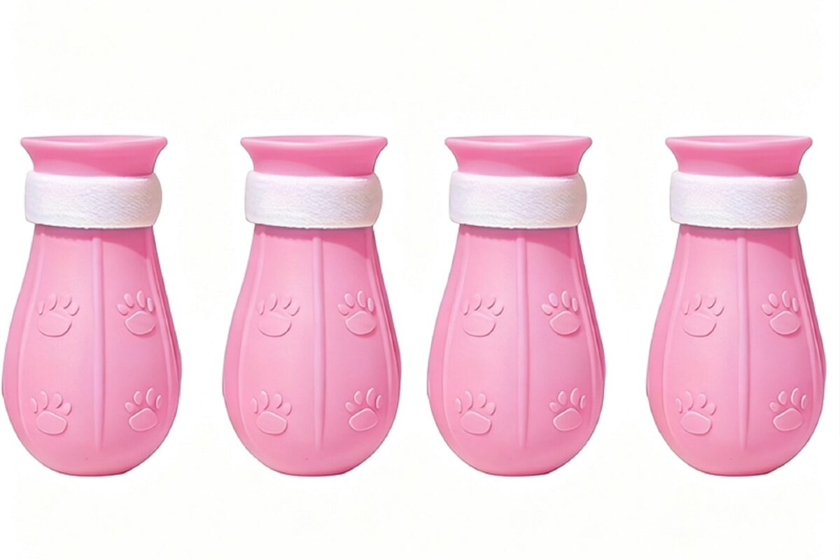 Four pink silicone pet paw covers with white fastening straps